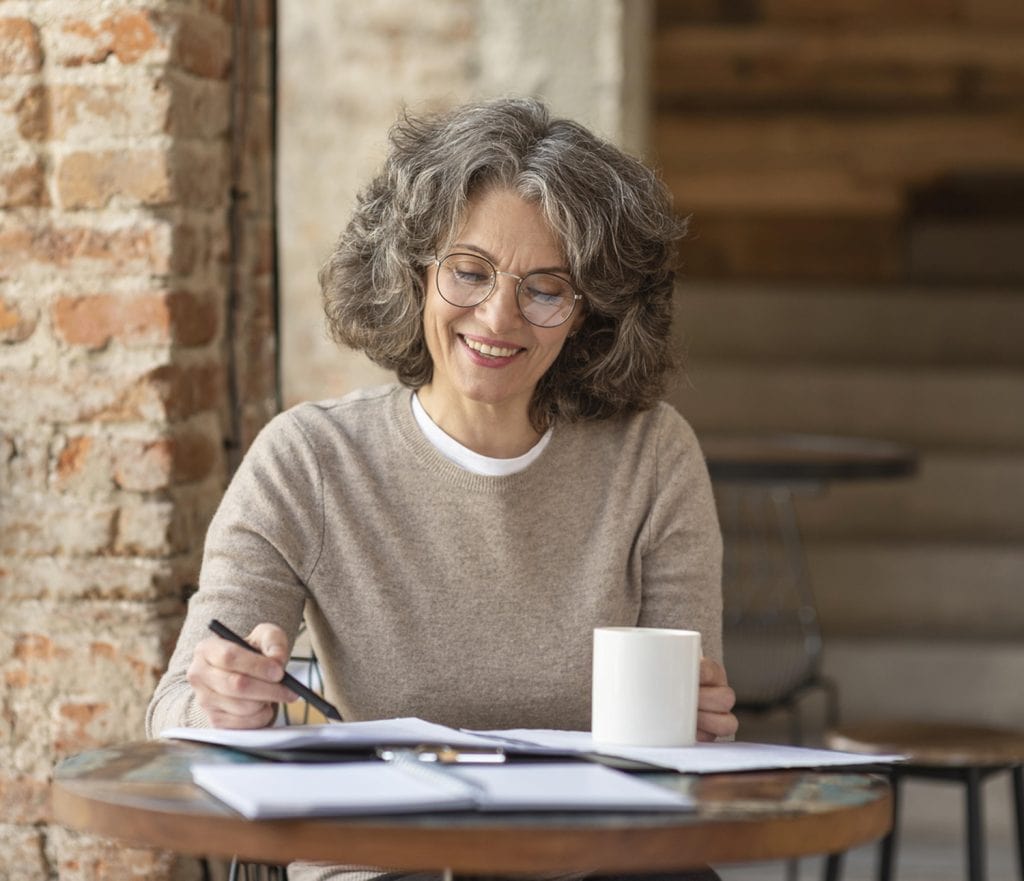 A smiling woman working at a desk.